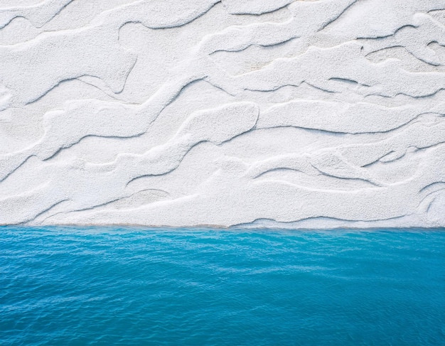 Photo folded paper design that forms the edge of the beach with a blue ocean background