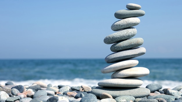 Folded pyramid of smooth stones on the seashore. rest and relaxation on vacation