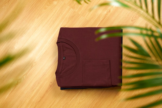 Folded red tshirt against a wooden background