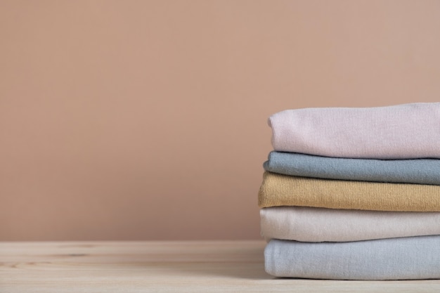 folded stack clothes on beige background wall