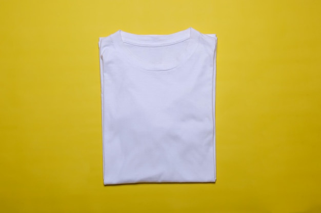 Folded white tshirt mockup on yellow background Flat lay tee template