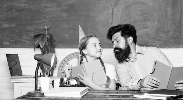 Following example Girl pupil study with bearded teacher Studying methods for children School education Extra classes Cognitive skills concept Schoolgirl likes study with father Study hard