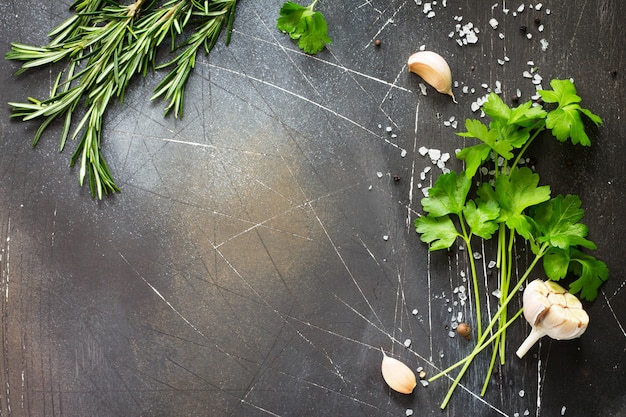 Food background Parsley and rosemary on a dark stone table Copy space top view flat lay