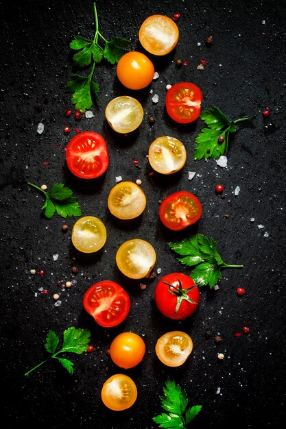 Food background red yellow and orange cherry tomatoes black background top view