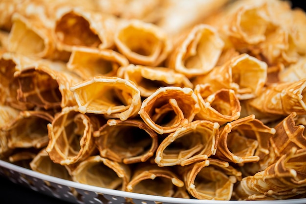 food, baking, cooking and eating concept - close up of waffle cones or rolls