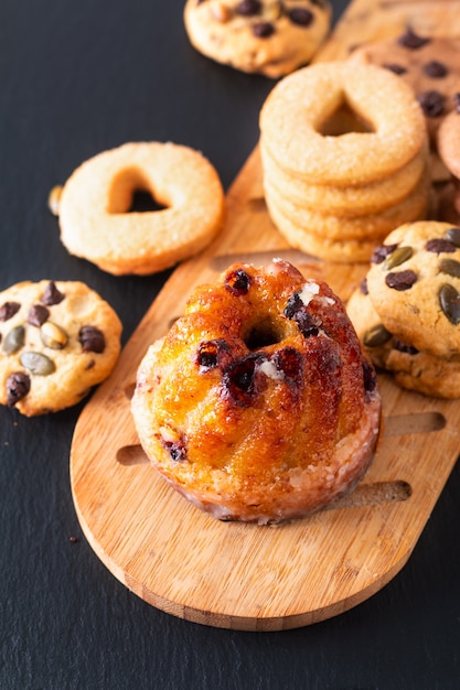 Food Breakfast or snack european Gugelhupf, Kougelhopf, kouglof yeast Bundt ring cake with cookies on black