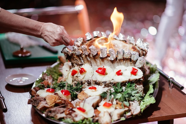 Food concept Ready grilled pork ribs dish and beef steak with herbs Ready to serve Ready to eat Two chefs working in the background interior of modern professional restaurant kitchen