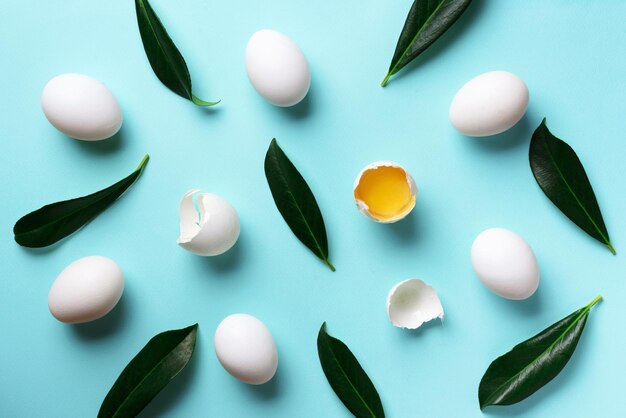 Photo food concept with white eggs green leaves on blue color top view creative pattern in minimal style flat lay