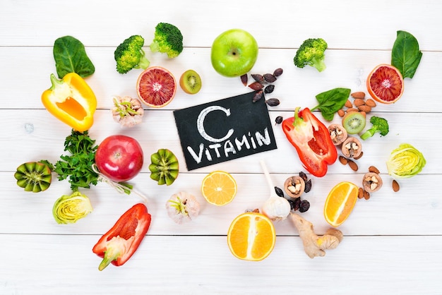 Food containing natural vitamin C Orange lemon apple rose garlic broccoli apple kiwi spinach Top view On a white background