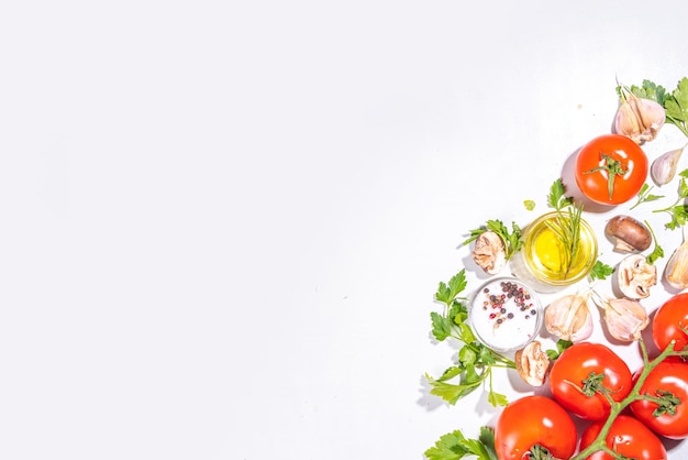 Photo food cooking preparation background kitchen table background with spices herbs vegetables parsley onion garlic tomatoes salt olive oil on a white background top view flatlay copy space