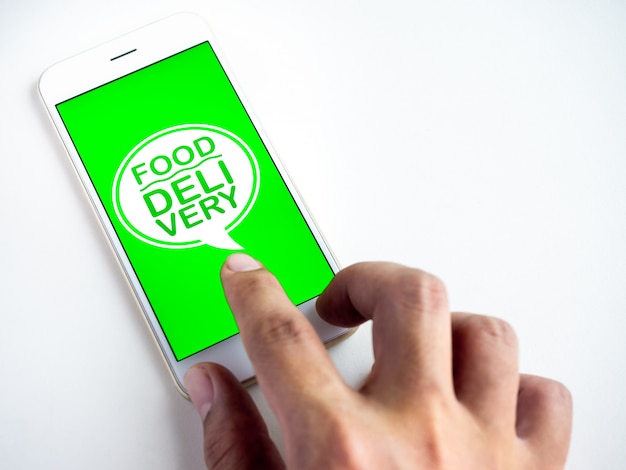 Food delivery concept. Words "FOOD DELIVERY" on smartphone screen. Ordering food by smartphone technology.