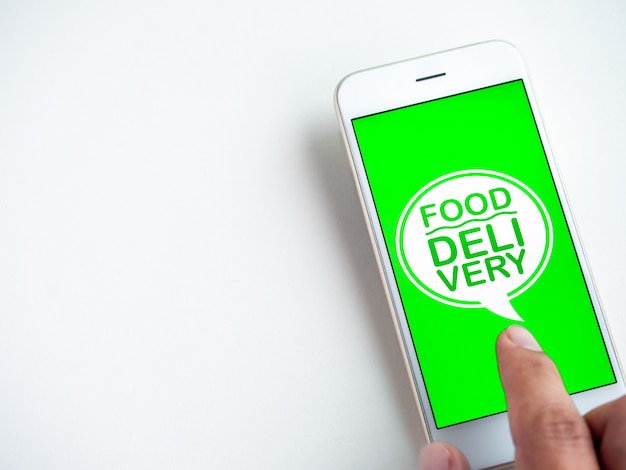 Food delivery concept. Words "FOOD DELIVERY" on smartphone screen. Ordering food by smartphone technology.