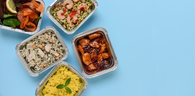 Food delivery. Different aluminium containers with healthy diet natural food. Top view