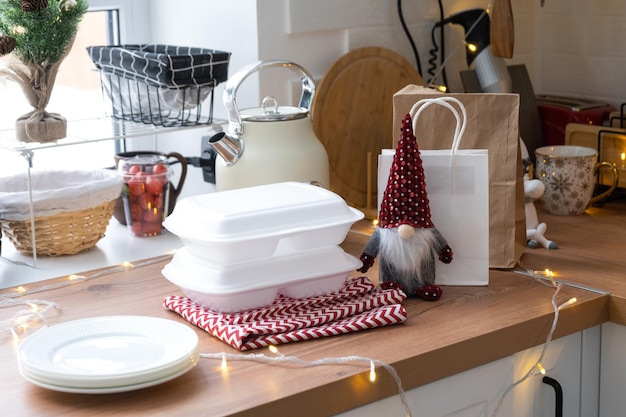 Food delivery service containers on table white scandi festive kitchen in christmas decor Eve New year saving time too lazy to cook hot order disposable plastic box in fairy light mock up