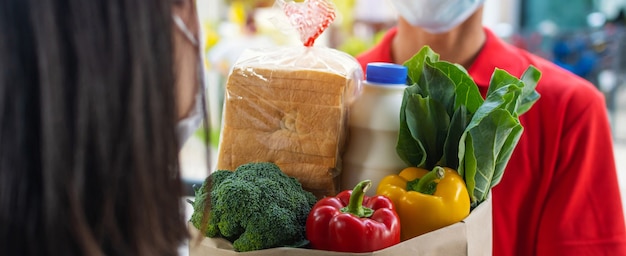 food delivery service man wearing protection face mask handing fresh food set bag