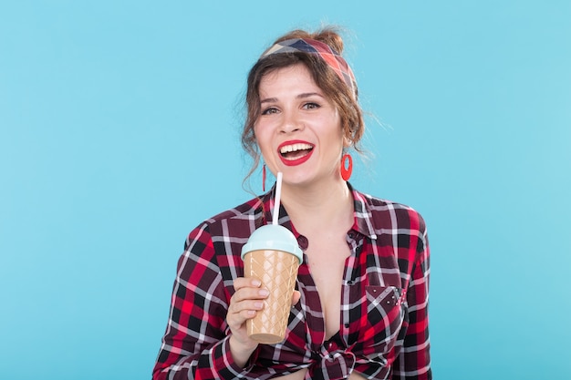 Food, diet and fun concept - woman in pin-up style with glass of coffee.