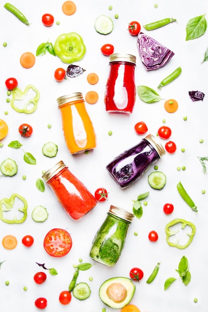 Food and drink background Colorful vegan vegetable juices and smoothies set in bottles on white....