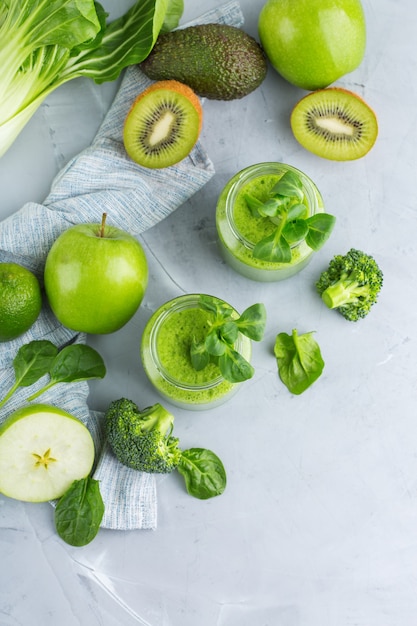 Food and drink, healthy dieting and nutrition, lifestyle, vegan, alkaline, vegetarian concept. Green smoothie with organic ingredients, vegetables on a modern kitchen table. Copy space background