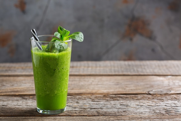 Food and drink, healthy dieting and nutrition, lifestyle, vegan, alkaline, vegetarian concept. Green smoothie with organic ingredients, vegetables on a wooden kitchen table. Copy space background