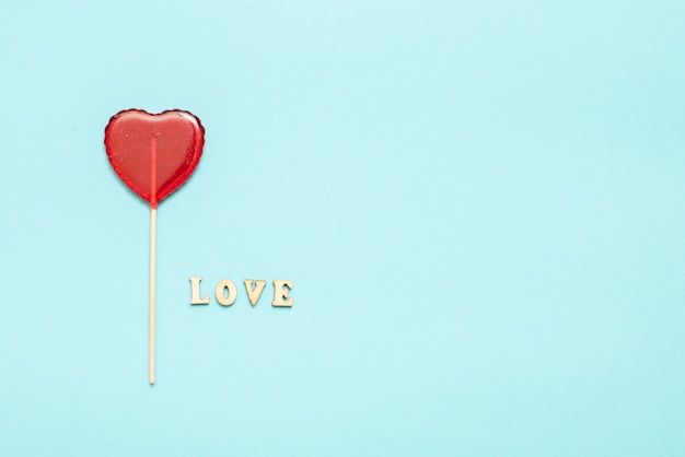 Food and drink, holidays concept. Heart shaped lollipop for love Valentines Day with blue background. Copy space