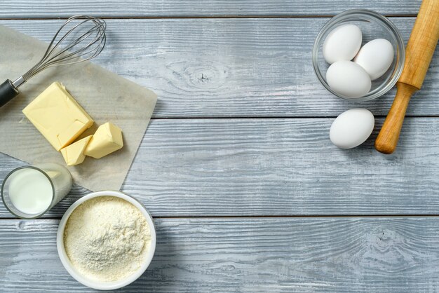 Food frame with ingredients for baking on the background of a light wooden table