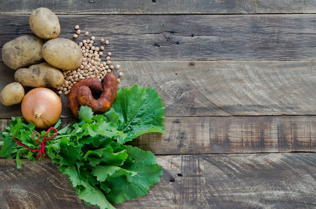 Food ingredients, chorizos, potatoes, onions, chickpeas and turnip tops.