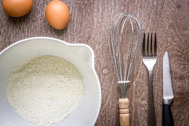 Food ingredients and kitchen utensils for cooking on wooden background