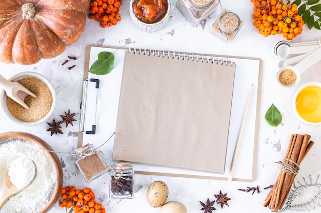 Food ingredients for making autumn pumpkin pie on white stone background Homemade baking concept