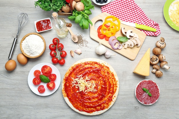 Food ingredients for pizza on table close up