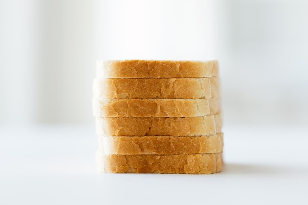 food, junk-food and unhealthy eating concept - close up of white sliced toast bread pile on table