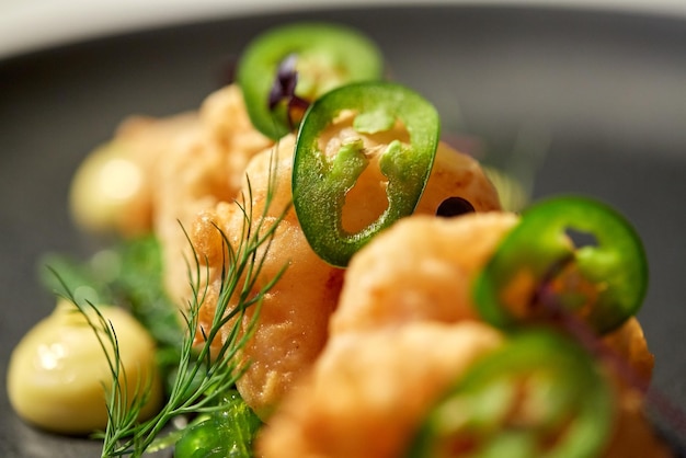 food, new nordic cuisine, culinary and cooking concept - close up of king prawns with jalapeno on plate