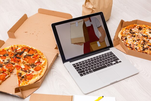 Photo food order concept. close-up top view of a ordering pizza with a laptop. all screen graphics are made up.