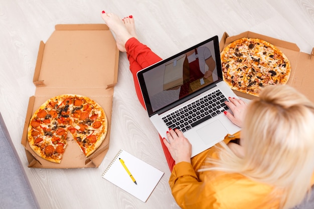 Photo food order concept. close-up top view of a ordering pizza with a laptop. all screen graphics are made up.