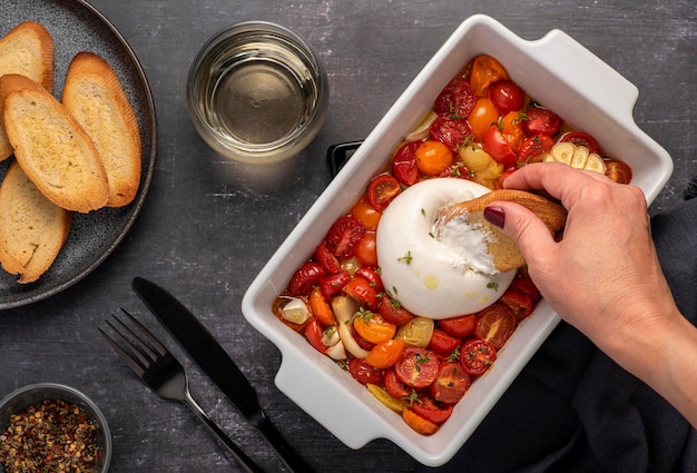 Food photography of burrata with baked tomatos and toasts