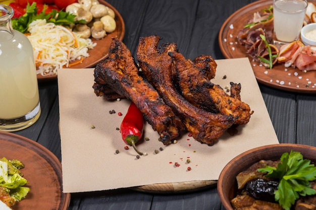 Food set with grilled pork ribs on black wooden background