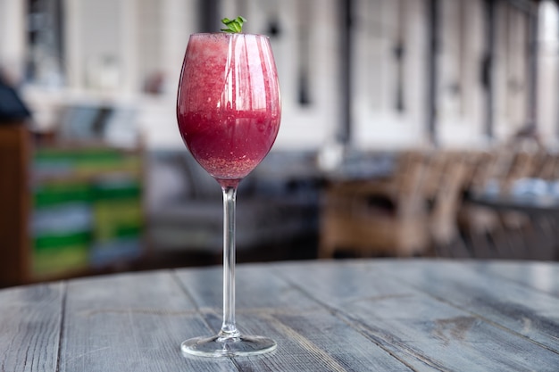 Food shooting. Berry cocktail in crystal glass decorated mint, berries, pomegranate, orange, pineapple.