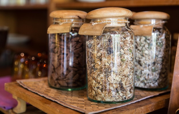 food, storage and eating concept - close up of jars with granola at grocery store