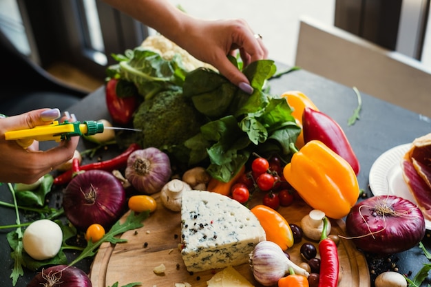 Food stylist spraying and preparing vegetables. Blogger at work. Leisure hobby art design concept