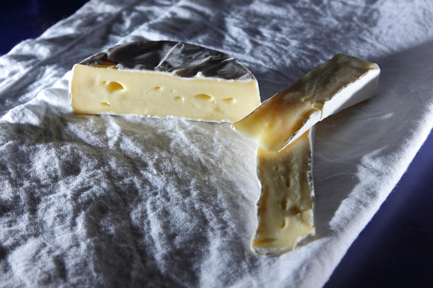 Food for wine Delicious white cheese on the table closeup Slices of fresh camembert on a white napkin