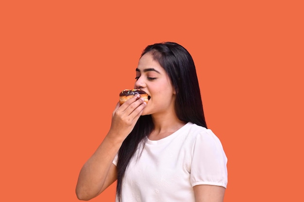 foodie girl wearing white t-shirt and eating chocolate dount indain pakistani model