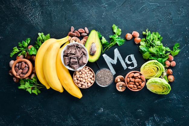 Foods containing natural magnesium Mg Chocolate banana cocoa nuts avocados broccoli almonds Top view On a black background