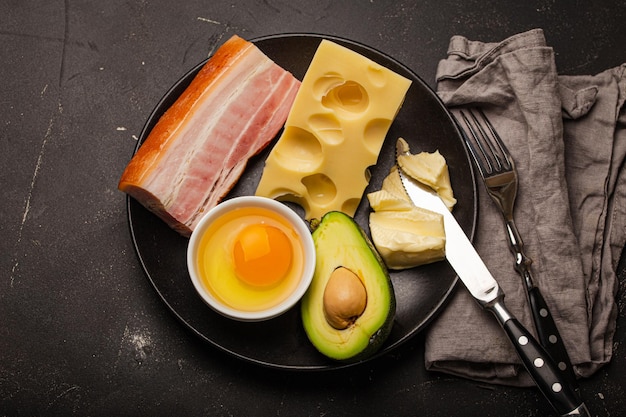 Foods for keto diet on black plate on dark background