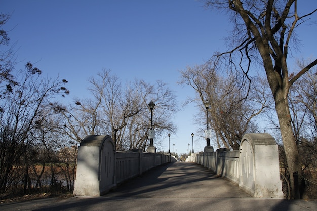 Foot bridge crossing the Assiniboine river with trees in the winter Assiniboine Park Manitoba