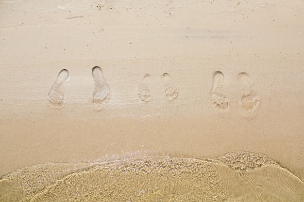 Photo foot tracks on the sand. footprints on the sandy beach.