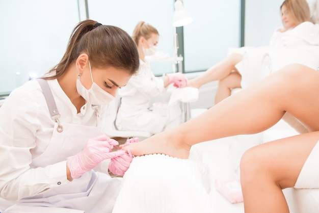 Foot treatment for two friends or sisters in SPA salon.