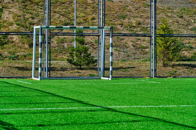 Football field with gate and freshly laid green lawn