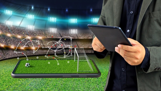 Football manager with game strategy on smartphone. soccer field