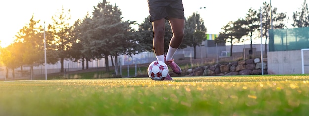 Football player on the field running with the ball Close up of player39s feet running with the ball on the field Player feet with the ball scoring a goal