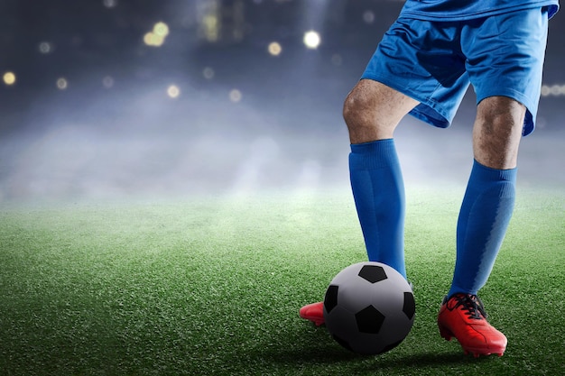 Football player man in a blue jersey standing with the ball