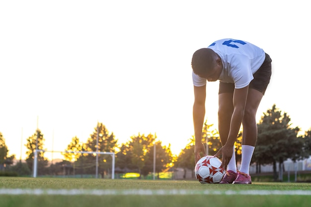 Football player placing the ball on the grass Low angle of football player putting the ball on the grass in free kick